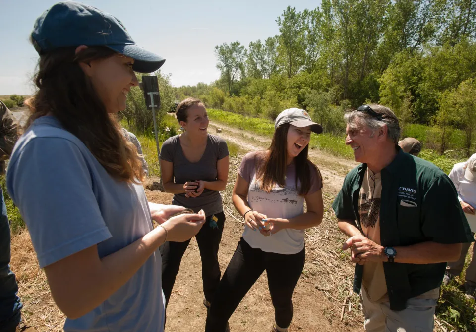 Professor with students outside near wetland area